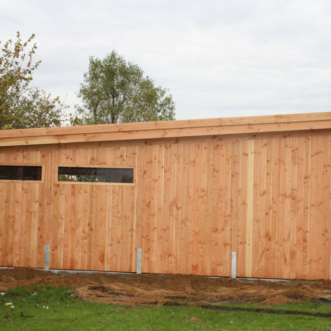 Ein Pultdachcarport von der Seite mit Fenstern.